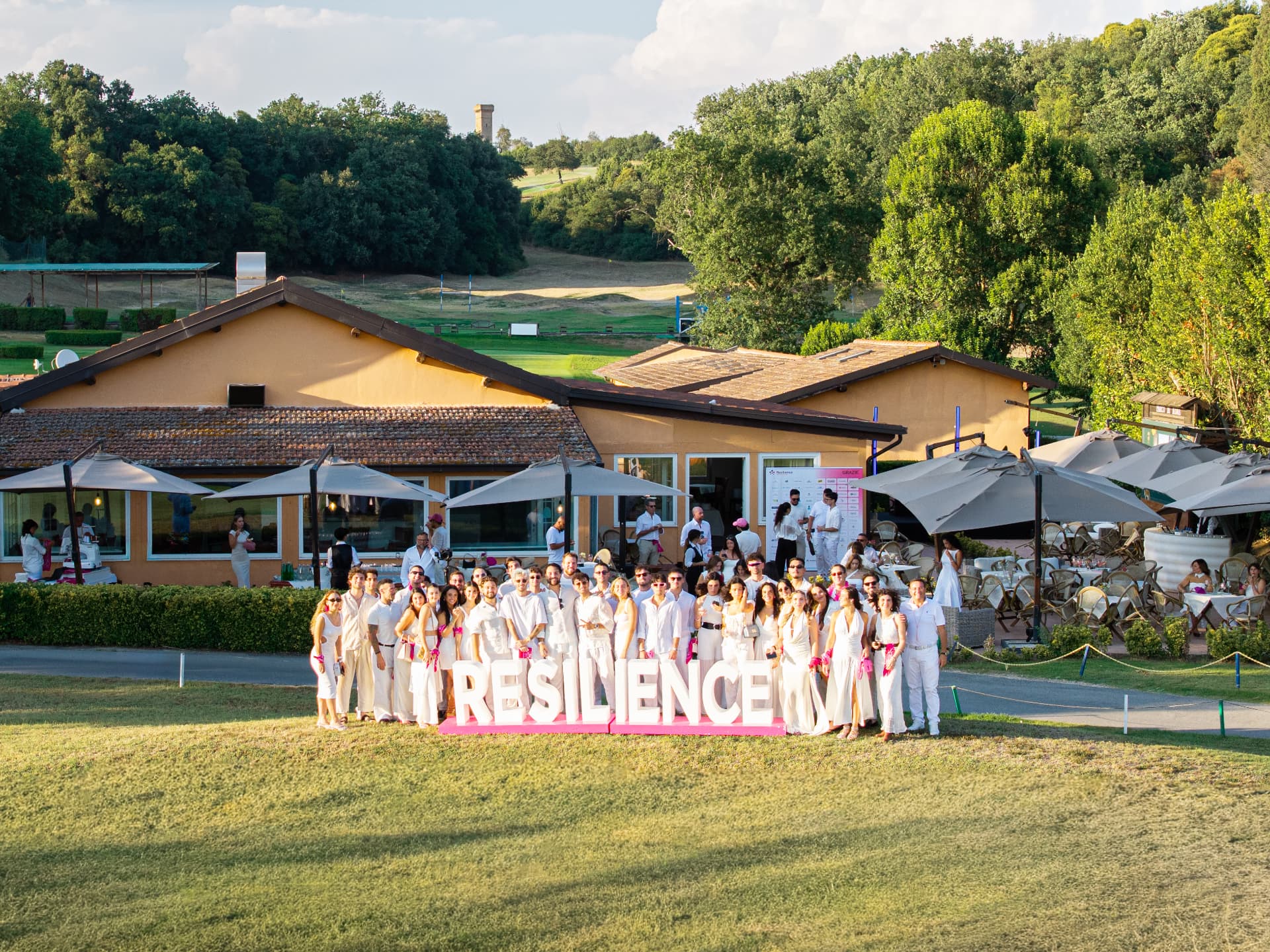 Il team Resilience in bianco davanti alla scritta RESILIENCE al White Party