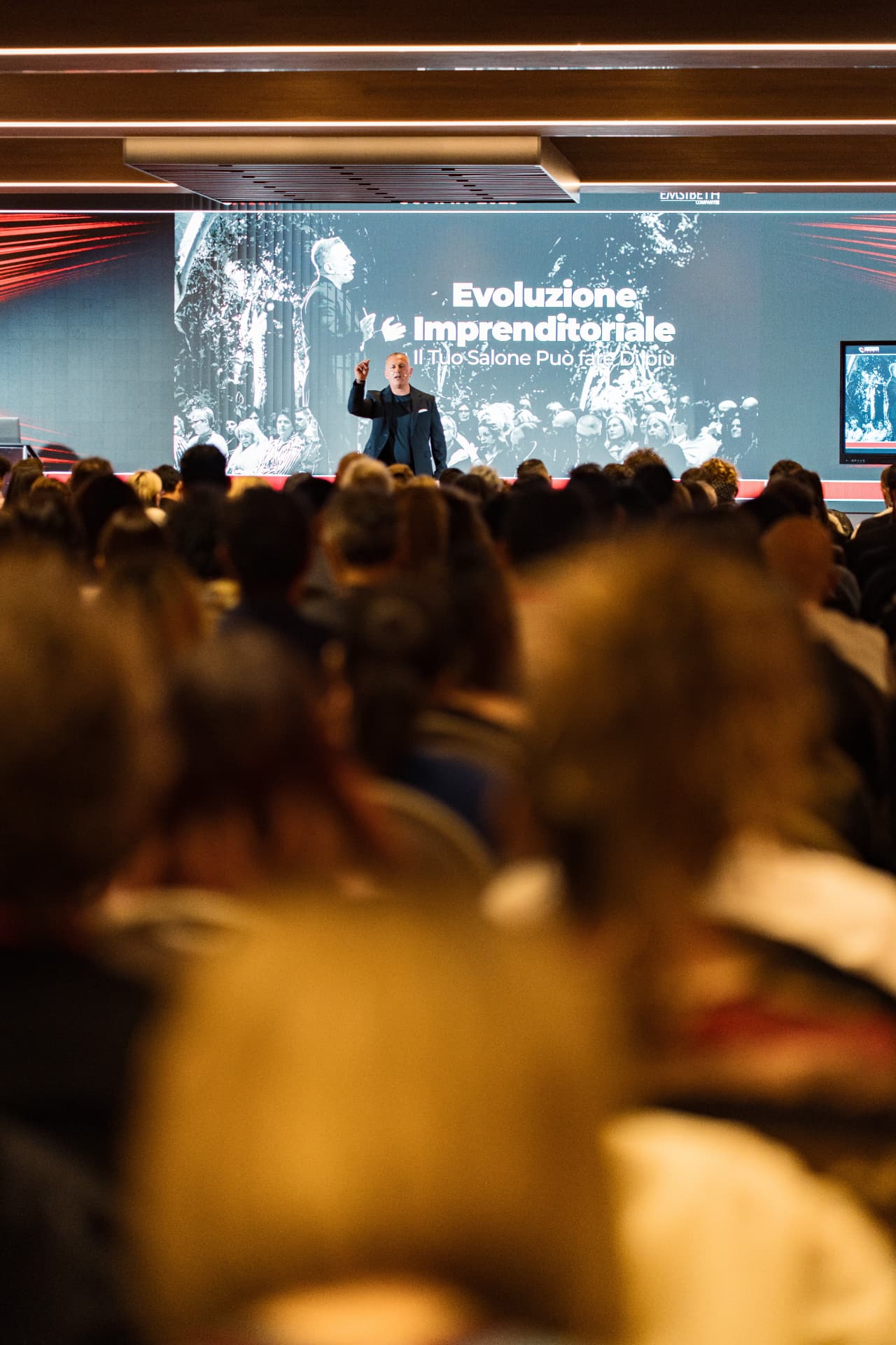 Convention aziendale: speaker sul palco davanti alla platea