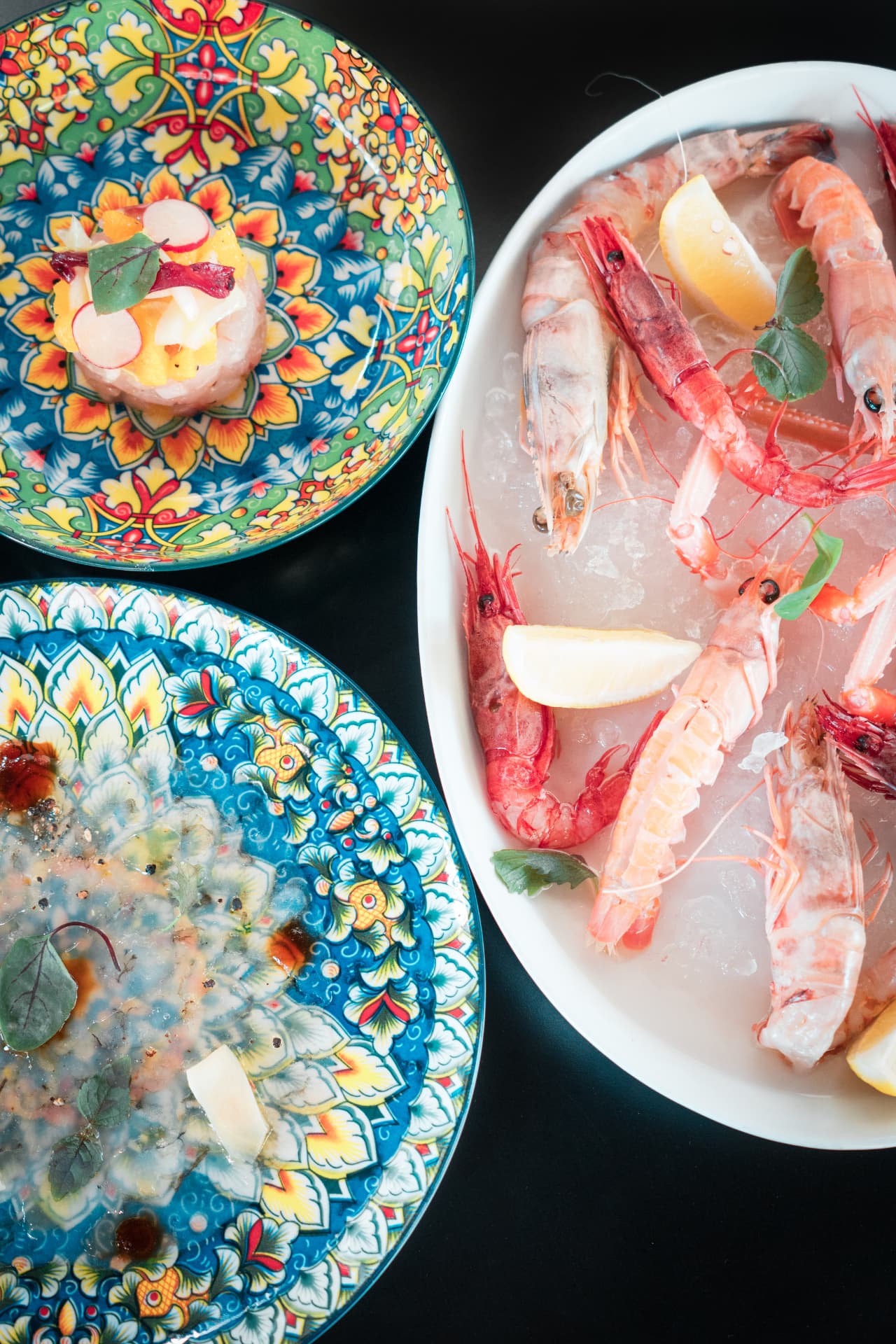 Still life food: crudi di mare su piatti decorati
